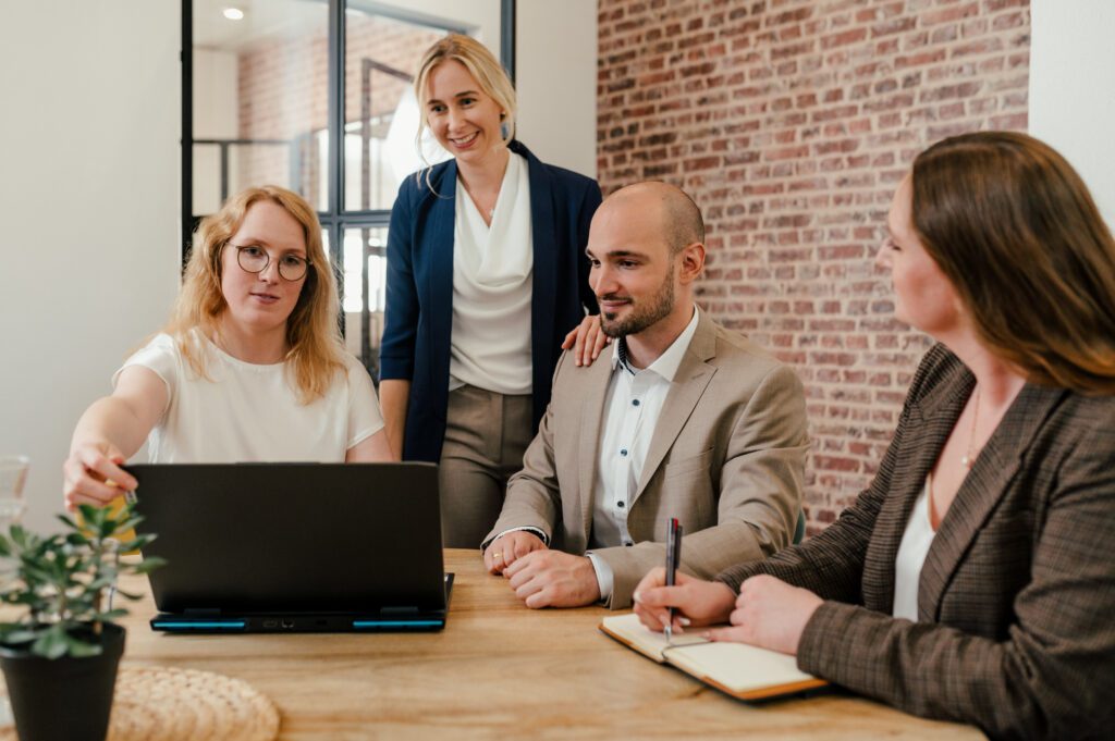 Vier Personen besprechen am Laptop die Strategie der Recruiting-Kampagne