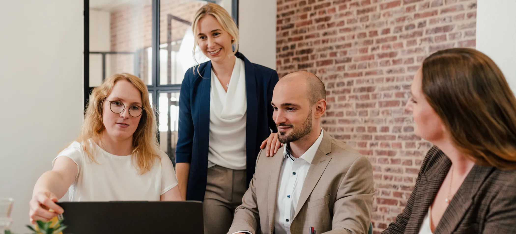Vier Mitarbeitende von Daily Marketing besprechen gemeinsam eine Kampagne am Laptop